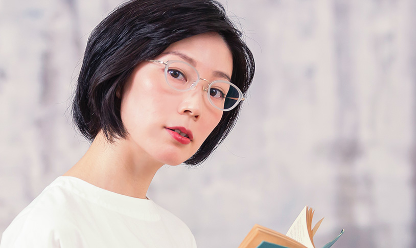 メガネをかけて本を読んでいる女性